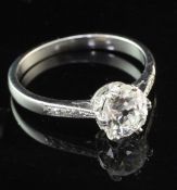 A platinum and single stone diamond ring with diamond set shoulders, the central old cut stone