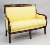 A French Empire ormolu mounted mahogany settee, with yellow silk upholstery, parcel gilt dolphin