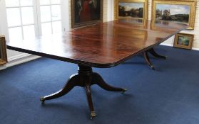 An early 19th century mahogany extending twin pillar dining table, with one extra leaf, each