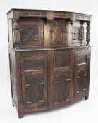 A 17th century style oak court cupboard, incorporating older timbers, fitted with arched panelled