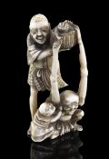 A Japanese ivory okimono of Ashinaga and Tenaga, Meiji period, the two figures holding aloft a