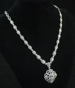 An 18ct white gold and diamond pendant necklace, set with emerald cut diamonds within brilliant