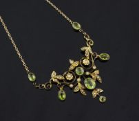 An Edwardian gold, peridot and seed pearl set pendant, of scrolling foliate design, on a 9ct gold