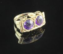 A 14ct gold and amethyst dress ring, of rectangular concave form, with ornate scroll mount and set