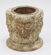 An unusual Continental carved limewood basket or planter, carved with Green Man faces, on circular