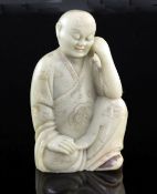 A Chinese soapstone seated figure of a luohan, 17th / 18th century, his robes engraved medallions