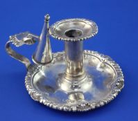 A late Victorian silver chamberstick and snuffer, of circular form, with shell and gadrooned border,