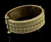 A Victorian gold hinged bangle, with continuous geometric cannetile work decoration and central