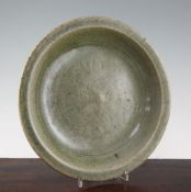 A Chinese Longquan celadon dish, 15th century, the well incised with a flower and foliage, burnt