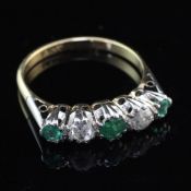 An early to mid 20th century 18ct gold, emerald and diamond ring graduated five stone half hoop