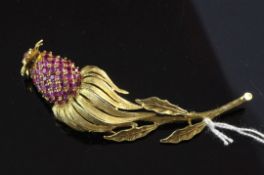 An 18ct gold and ruby trembleuse brooch modelled as an exotic fruit, set with cabochon and round cut