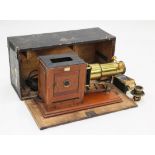 A Newton & Co lacquered brass and mahogany magic lantern, converted to electricity, with a plaque