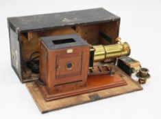 A Newton & Co lacquered brass and mahogany magic lantern, converted to electricity, with a plaque