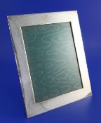 An Edwardian plain silver mounted rectangular photograph frame, with engraved armorial above the