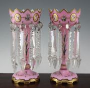 A pair of Victorian pink and white overlaid glass table lustres, with crenellated rims, decorated