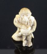 A Japanese ivory netsuke of a seated monkey holding a peach, signed Kogetsu, Meiji period, the