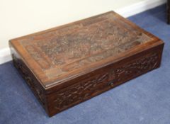 A large Chinese rosewood box, early 20th century, the hinged cover carved in relief with three