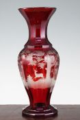 A Bohemian ruby glass multi-facetted baluster vase, late 19th century, wheel engraved with deer in a