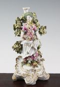 A Derby candlestick figure, c.1770, modelled as a lady holding a basket of flowers in her apron