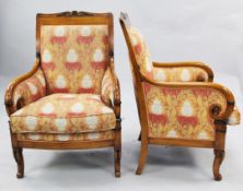 A pair of French Empire style parcel ebonised beech fauteuils, with upholstered backs, arms and