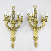 A pair of Louis XVI style gilt brass twin branch wall lights, each with a ribbon tied crest and