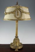 An early 20th century ormolu table lamp, the circular fabric shade with floral swag mounts, 23in.