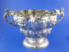 A late Victorian repousse silver two handled punch bowl, of circular form, with lobed border and