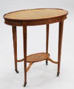 An Edwardian oval mahogany two tier occasional table, the square section tapering supports with bell