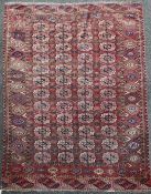 A Bokhara rug, with field of forty eight polygons on a red ground, with five row border, 8ft 8in