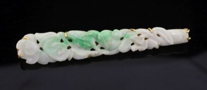 A gold mounted jadeite bar brooch, of tapering form and carved with flowers, 2.75in.