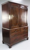 A George III mahogany linen press, with two fielded panelled doors revealing four sliding trays