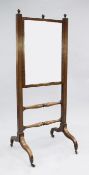 A Regency mahogany cheval mirror, with rise and fall action, baluster turned stretchers, downswept