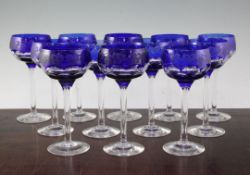 A set of twelve John Walsh blue flashed cut champagne glasses, with wheel engraved fruiting vine