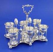 An Edwardian silver egg cruet, of rectangular form, with cusped border, engraved armorial and