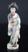 A Japanese coloured ivory figure of a bijin, early 20th century, the standing figure wearing a