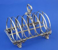 A Victorian silver seven bar toast rack, by The Barnards, with shaped ring handle, on scroll feet,