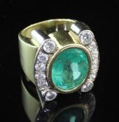 A stylish gold and platinum, emerald and diamond dress ring, with central oval cut emerald