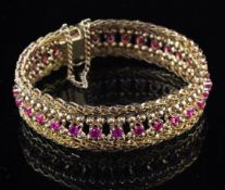 A Middle Eastern 18ct gold and ruby bracelet, with pierced decoration and set with thirty one