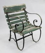 A green painted station armchair, with wrought iron sides and wooden slats