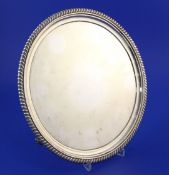 A George IV silver circular salver by John Mewburn, with gadrooned border, on three winged paw feet,