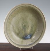 A Jun type dish, 13th - 15th century, with pale orange green glaze and white / violet hints to the