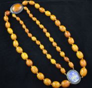 A Victorian double strand graduated amber bead necklace, with amber and blue guilloche enamel set