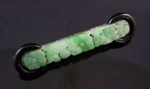 A white gold mounted black onyx and jadeite bar brooch, the jade with pierced foliate carving and