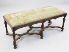 A late 17th century style walnut stool, with tapestry upholstered drop in seat, on six turned