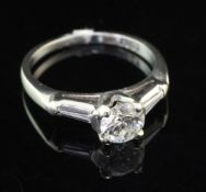 An 18ct white gold and single stone diamond ring with trapeze cut diamond set shoulders, the central