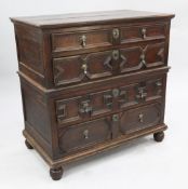 An early 18th century oak chest, of four graduated long drawers with geometric moulding, on ball