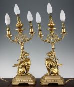 A pair of late 19th / early 20th century gilt bronze griffin three light table lamps, on a stepped