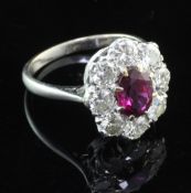 An 18ct white gold, ruby and diamond cluster ring, of oval form, with an estimated total diamond