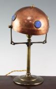 A Jugendstil copper and brass table lamp, with adjustable domed shade, mounted with circular