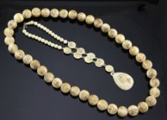 Two Japanese carved ivory necklaces, early 20th century, the first a bead necklace, each bead